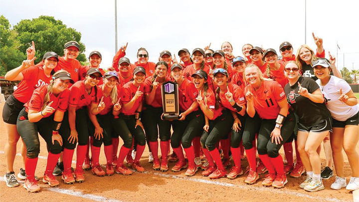 The SDSU softball team poses for a photograph with their conference trophy.