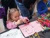 SDSU Center for Autism’s pipe cleaner neuron activity captures the attention of a young festival attendee. (Bryana Quintana/SDSU)