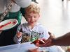 A young student smiles while getting an up close look at sea stars and other marine creatures with the Marine Ecology & Biology Student Association (MEBSA). (Bryana Quintana/SDSU)