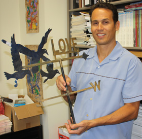 Anthropology Professor Seth Mallios with a weathervane from the home of former SDSU President Malcolm Love.