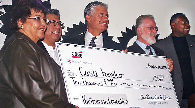James Kitchen (far right), Stephen Weber (second from right) and Eric Rivera (second from left) accept a check alongside Casa Familiar and SDG&E representatives.