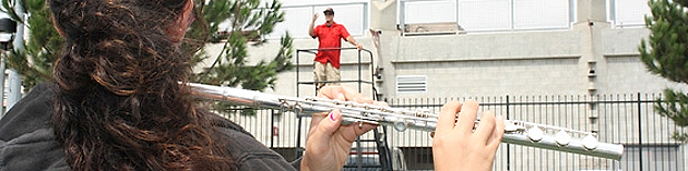A Marching Aztecs' flute player (foreground) follows Director of Athletic Bands Brian Ransom (background).