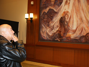 Guillermo Aranda examines the mural he painted