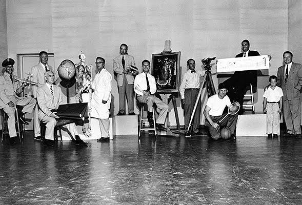 This 1955 photo features San Diego State College's division chairmen. Standing in the middle on the riser is SDSU's first chair of the humanities department, John R. Adams.