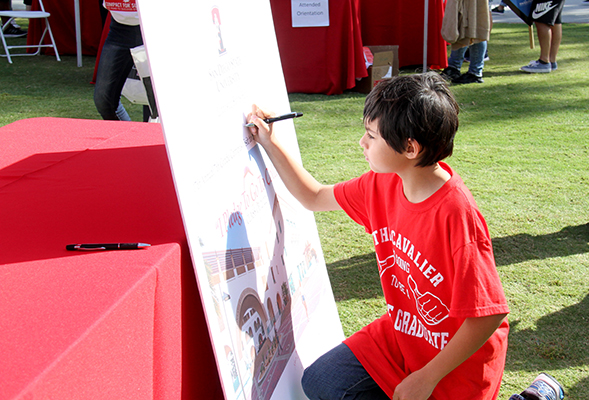 A student signs the I Pledge To Go To College board at the Compact for Success 7th Grade Visit to SDSU. (Credit: SDSU Student Affairs Communications Services)
