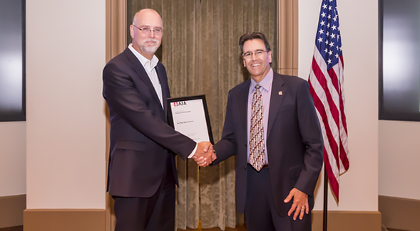 Robert Schulz, SDSU associate vice president of operations and university architect, shakes hands with AIA San Diego Chapter president Phil Bona (right).