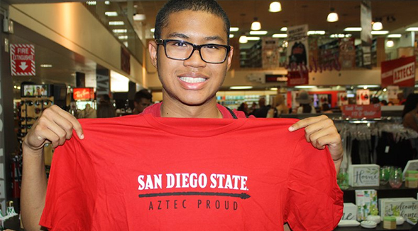 SDSU student Jacob Green holds up the Aztec Proud t-shirt he received after making a donation.