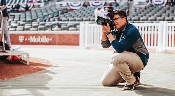 SDSU student Raymond Gorospe taking photos on the field at a Major League Baseball stadium. (Photo courtesy of Raymond Gorospe)