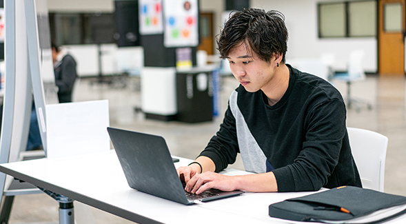 SDSU student working on laptop