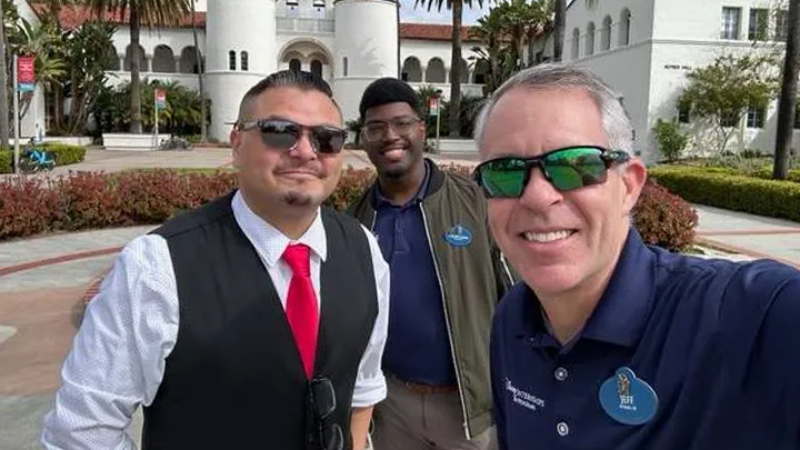 Andrew Soliz, SDSU Career Services, Courtland Jackson. Disney College & International Programs Recruiter, and Jeff Hickman, Manager, Disney College & Int’l Recruitment, take a selfie in front of SDSU's Hepner Hall.