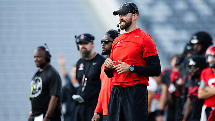 Aztecs coach Sean Lewis is shown calling plays from the sidelines at Snapdragon Stadium.