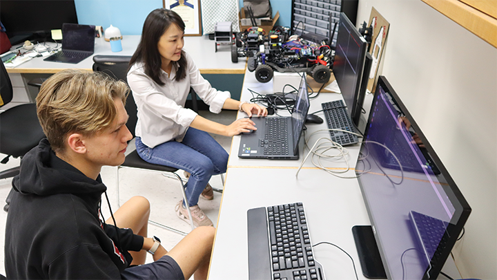 Fourth-year computer science student Pascal Reich and master’s student Hyunhee Kwak work at a computer developing software and advanced algorithms