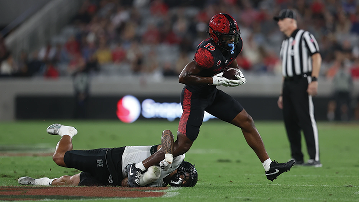 SDSU football player evades a tackle during a game at Snapdragon Stadium