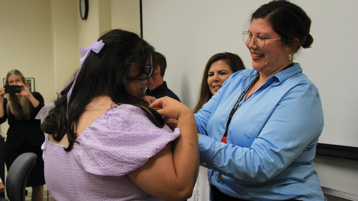 Linda Lara Jacobo, SDSU Imperial Valley assistant professor in public health, pinning one of the students on Oct. 11. 