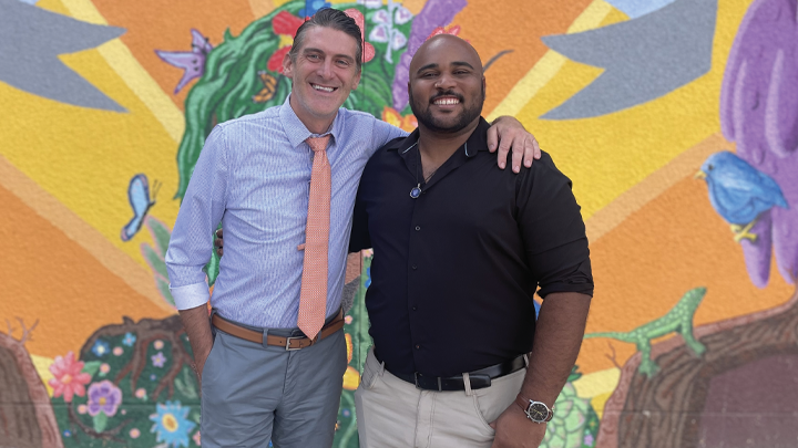 Amir Harrison and Timothy Farson photographed in front of a mural at the San Diego School of Creative and Performing Arts.