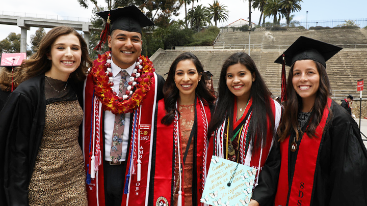 An SDSU student graduate shows off their decorated cap during a commencement ceremony