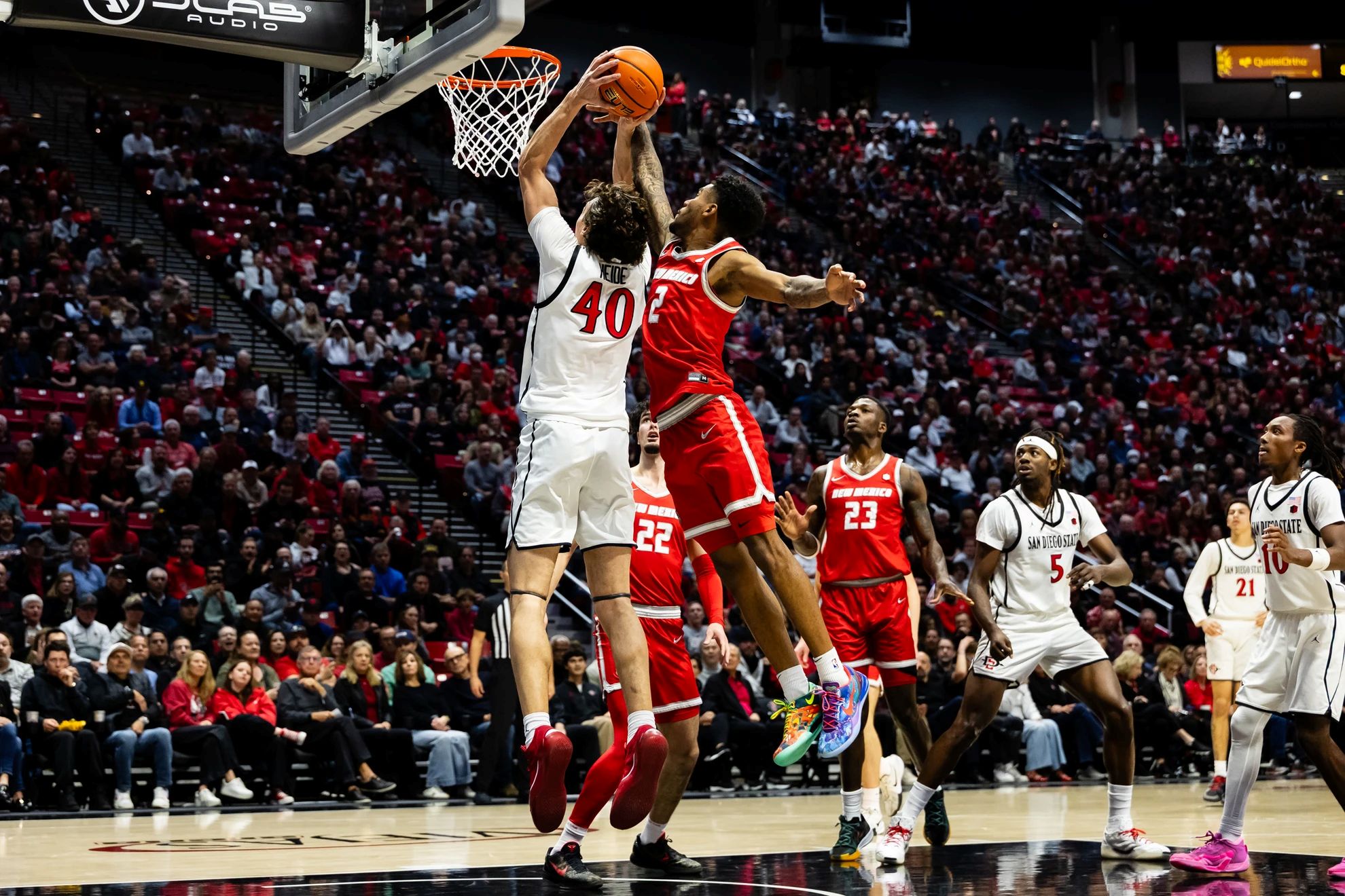 SDSU's Miles Heide takes flight to the basket against a New Mexico defender  