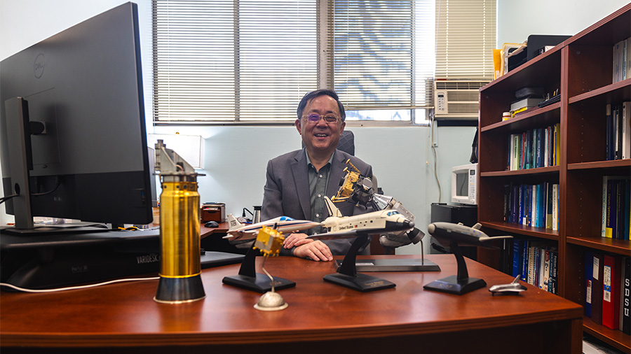 Surrounded by models of aircraft and spacecraft, Ping Lu celebrates his selection as the 2025 Albert W. Johnson University Research Lecturer. (Photo credit: Ky Marlin)