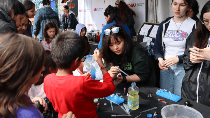 Members of SDSU’s Society of Women Engineers assist attendees with a build-your-own lava lamp activity at the 2024 San Diego Festival of Science and Engineering