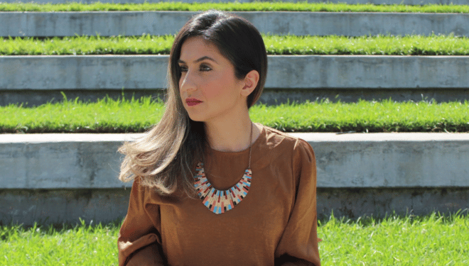 Photograph of Delveen Tahir sitting outdoors on a sunny day.