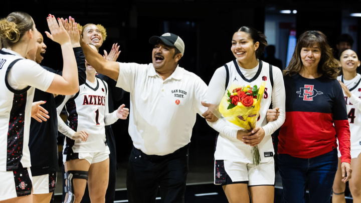 Enock Villalobos high fives his daughter’s teammates during senior night with Kim Villalobos (center) and her mom Silvia Estrada. (SDSU)