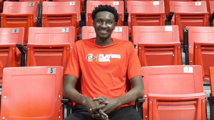 First-year international student Thokbor Majak sits in the stands after basketball practice at Viejas Arena.