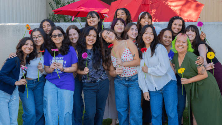 A group of students smile outside of SDSU's Women’s Resource Center